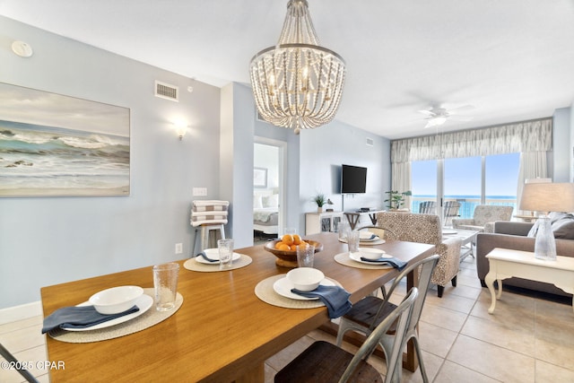 tiled dining area featuring ceiling fan with notable chandelier