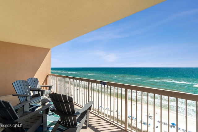 balcony featuring a water view and a beach view