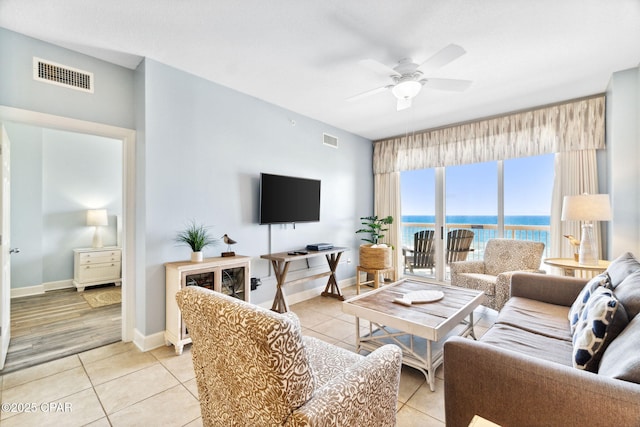 tiled living room with ceiling fan