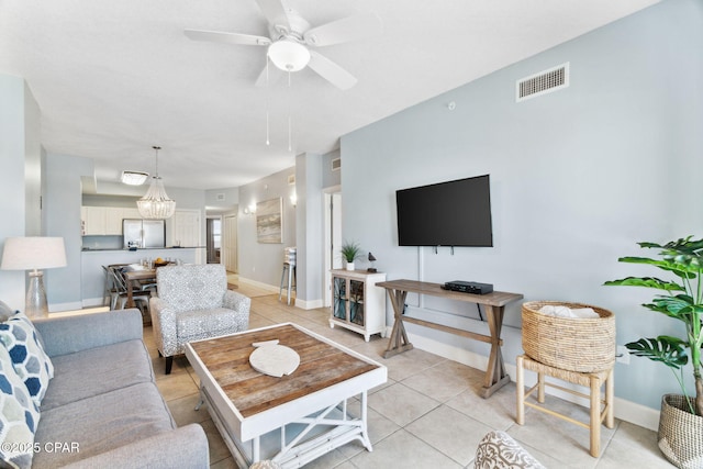 living room featuring ceiling fan with notable chandelier and light tile patterned floors