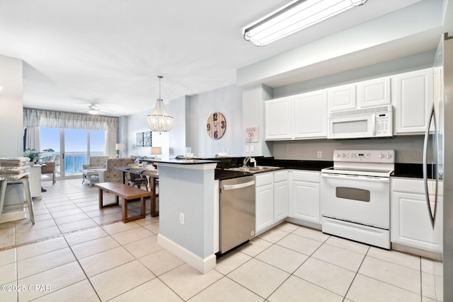 kitchen with white cabinets, appliances with stainless steel finishes, light tile patterned floors, and sink