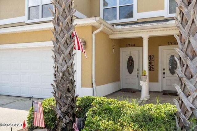 entrance to property with stucco siding and a garage