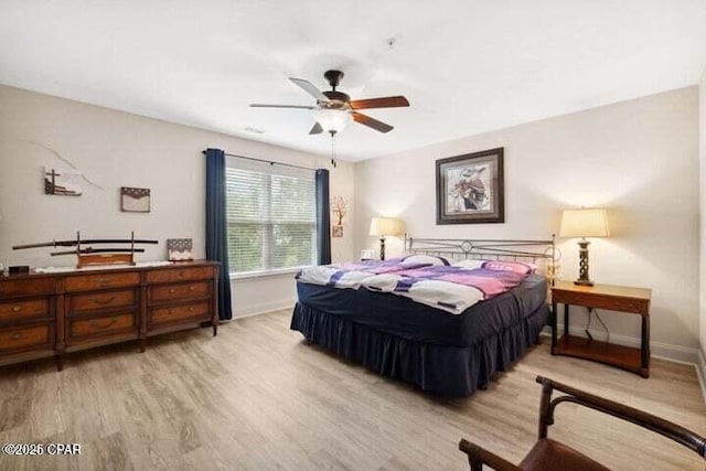 bedroom featuring ceiling fan, baseboards, and light wood-style flooring