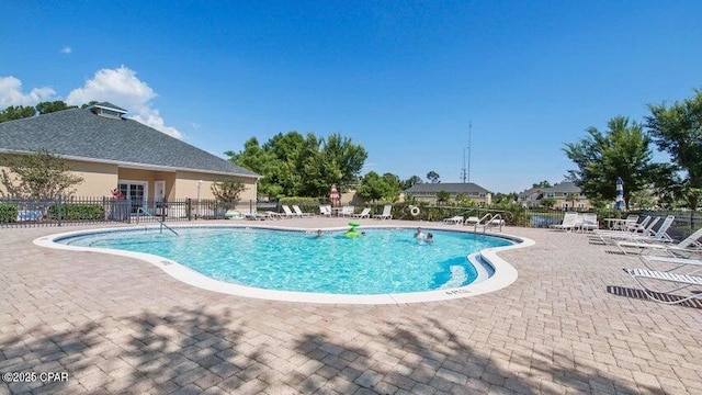 pool with a patio and fence