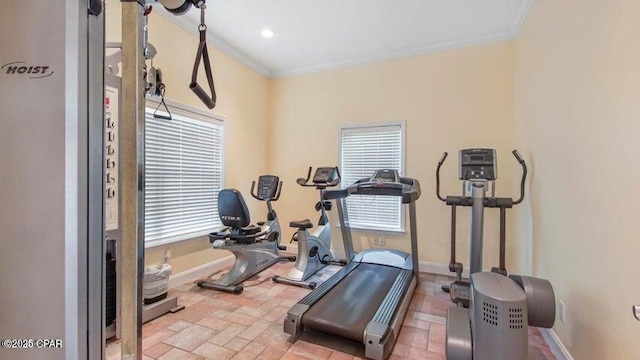 exercise area featuring crown molding, stone finish floor, and baseboards