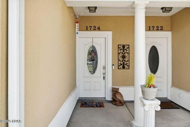 entrance to property featuring stucco siding and covered porch