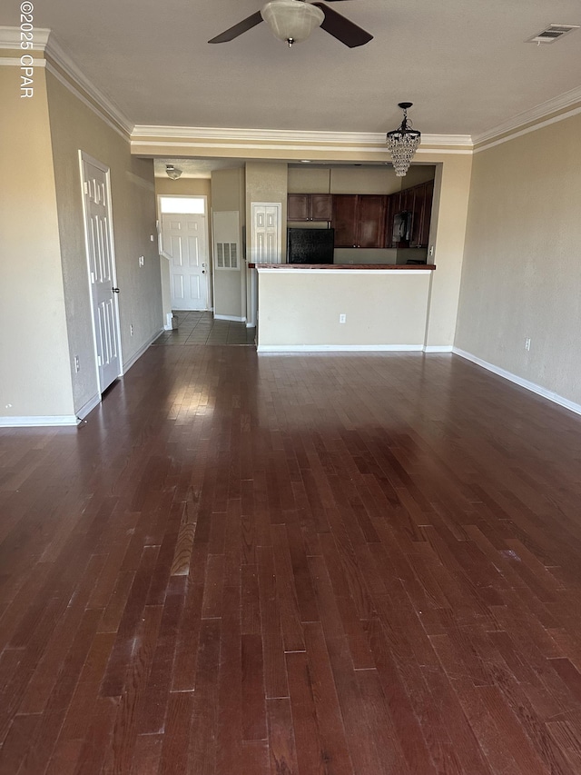 unfurnished living room with crown molding, ceiling fan, and dark wood-type flooring