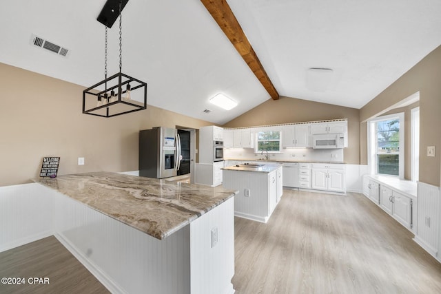 dining space featuring a stone fireplace, vaulted ceiling with beams, ceiling fan, and light hardwood / wood-style floors