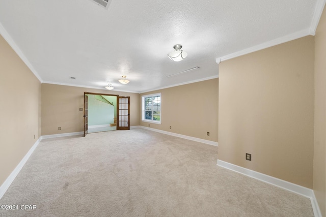 carpeted empty room with ornamental molding, a textured ceiling, and french doors