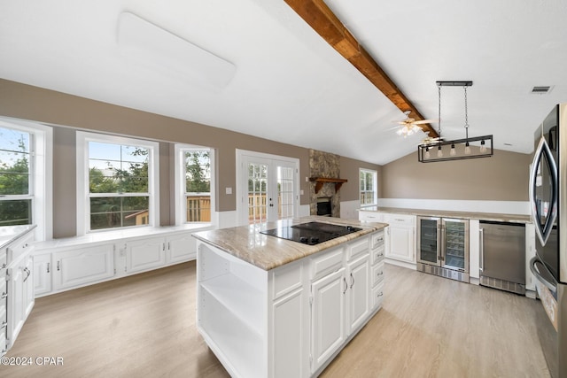 unfurnished living room featuring ceiling fan, a fireplace, lofted ceiling with beams, and light wood-type flooring