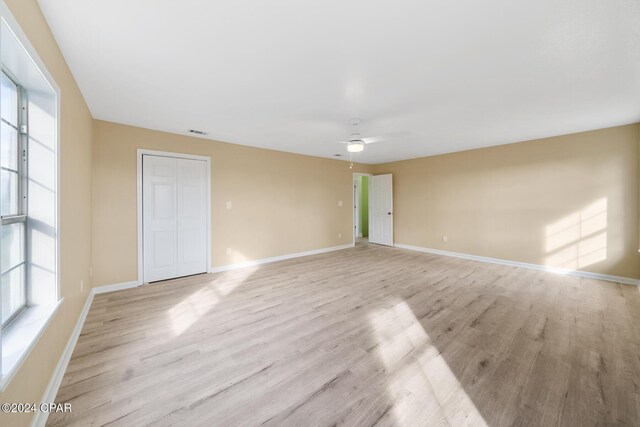 empty room with ceiling fan and light hardwood / wood-style floors