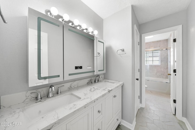 full bathroom with tile patterned floors, vanity,  shower combination, a textured ceiling, and toilet