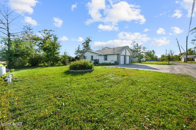 view of side of property with a yard and a garage