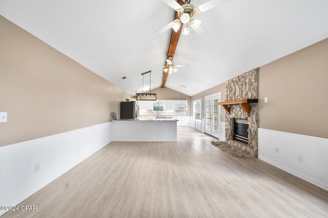 kitchen with stainless steel fridge, white cabinets, french doors, decorative light fixtures, and kitchen peninsula