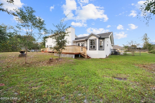 view of side of property featuring a wooden deck, a yard, and cooling unit