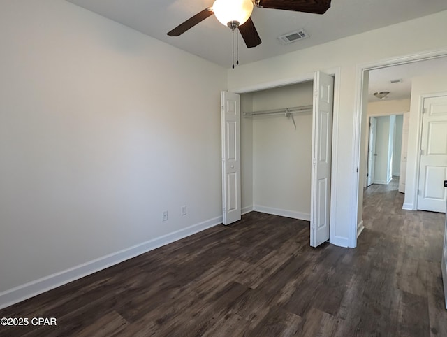 unfurnished bedroom with ceiling fan, a closet, and dark wood-type flooring