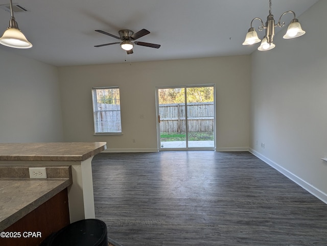 interior space with ceiling fan with notable chandelier and dark wood-type flooring