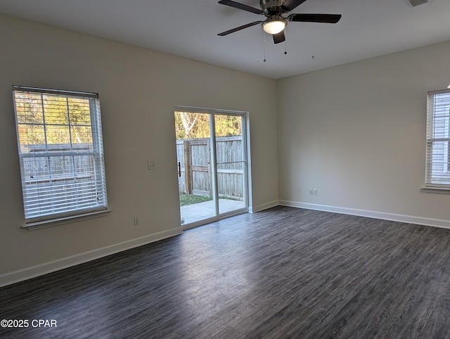 spare room featuring a wealth of natural light, dark hardwood / wood-style flooring, and ceiling fan