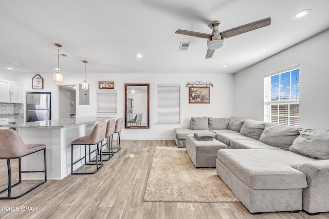 living room featuring light hardwood / wood-style floors and ceiling fan