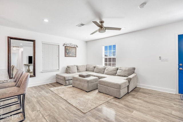 living room featuring light wood-type flooring and ceiling fan