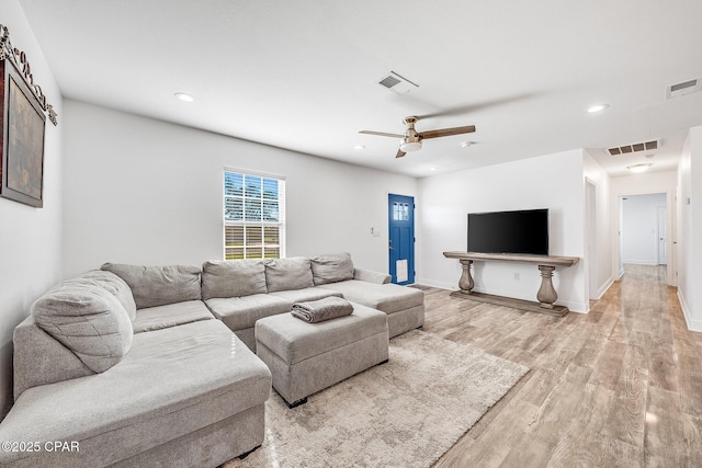 living room featuring light wood-type flooring and ceiling fan