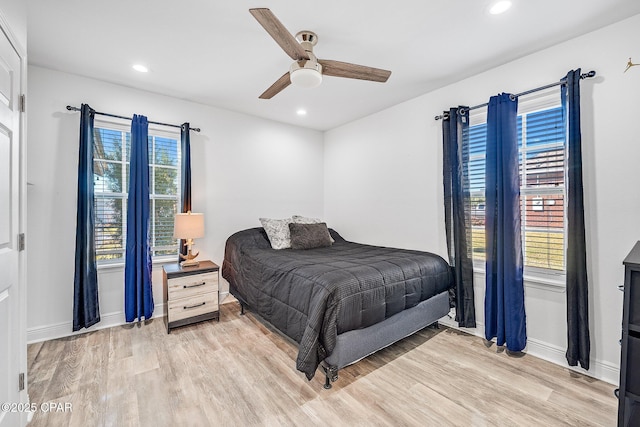 bedroom featuring multiple windows, ceiling fan, and light hardwood / wood-style flooring