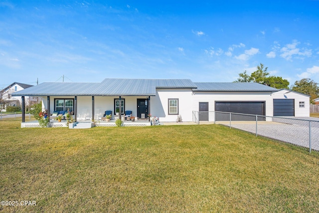 view of front of home featuring covered porch, a garage, and a front lawn