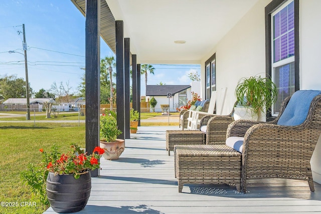 wooden terrace featuring covered porch and a yard