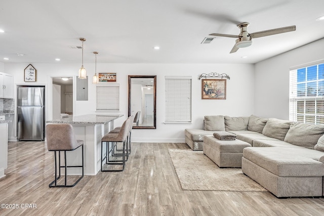 living room featuring ceiling fan and light hardwood / wood-style floors