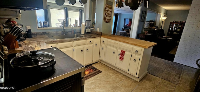 kitchen featuring sink, white cabinetry, and kitchen peninsula