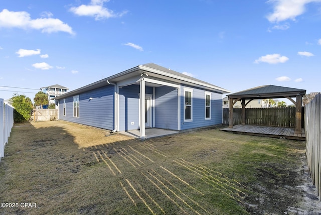 rear view of house featuring a gazebo, a yard, and a deck