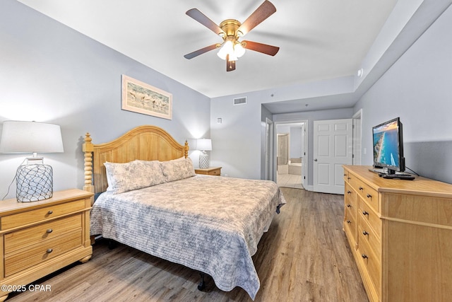 bedroom with ceiling fan, light hardwood / wood-style floors, and connected bathroom