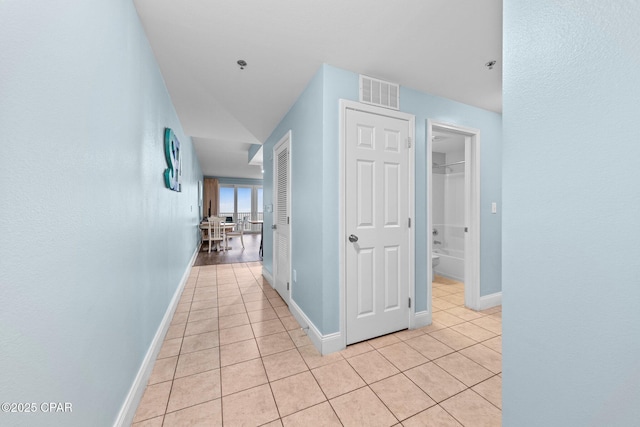 hall featuring light tile patterned floors