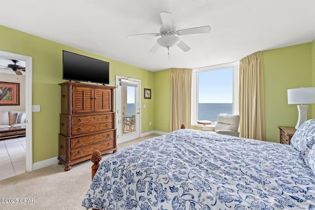 carpeted bedroom featuring access to outside, multiple windows, and ceiling fan