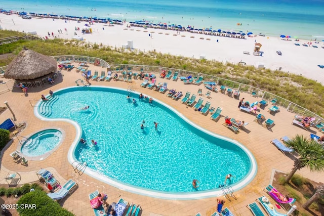 view of pool with a water view and a view of the beach