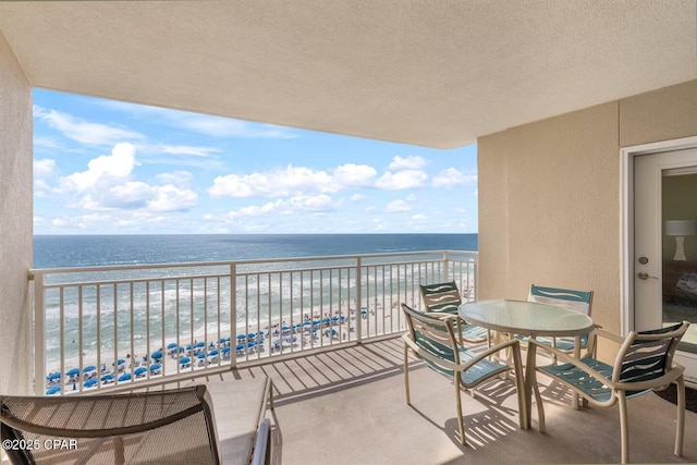 balcony featuring a water view and a beach view