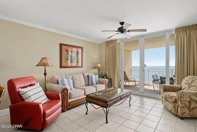 living room featuring expansive windows, ceiling fan, plenty of natural light, and a water view