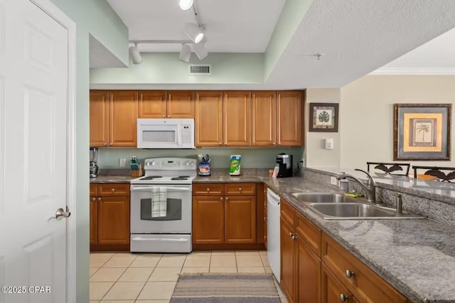 kitchen featuring sink, rail lighting, white appliances, light tile patterned floors, and ornamental molding