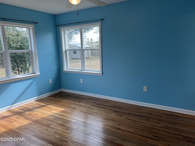 spare room with a wealth of natural light, hardwood / wood-style floors, and ceiling fan