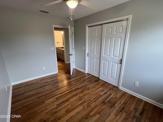 unfurnished bedroom with a closet, dark hardwood / wood-style floors, and ceiling fan