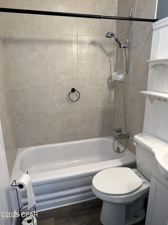 full bathroom featuring vanity, wood-type flooring, tiled shower / bath combo, and toilet