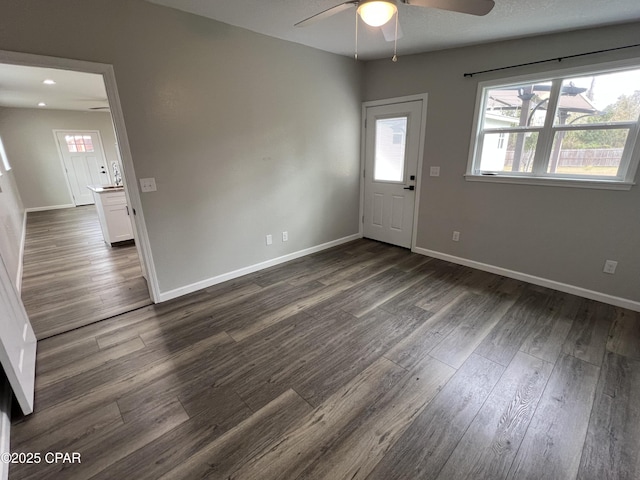 interior space with ceiling fan and dark hardwood / wood-style flooring