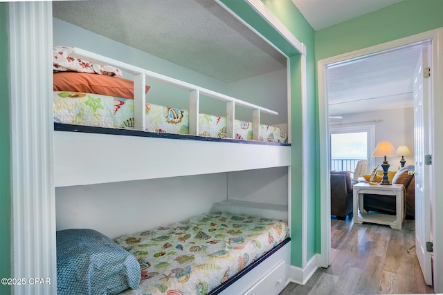 bedroom with a textured ceiling and hardwood / wood-style flooring