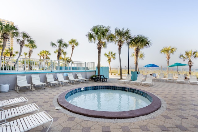 view of swimming pool featuring a patio area and a hot tub