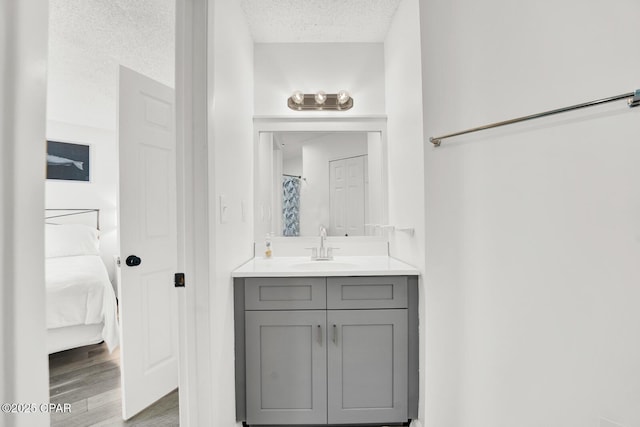 bathroom with vanity, a textured ceiling, and hardwood / wood-style flooring