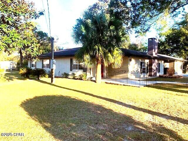 rear view of house featuring a lawn