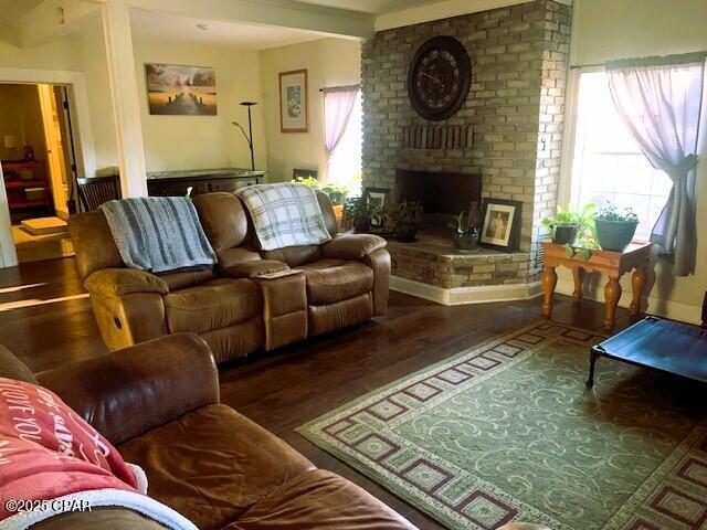 living room featuring a fireplace and dark wood-type flooring