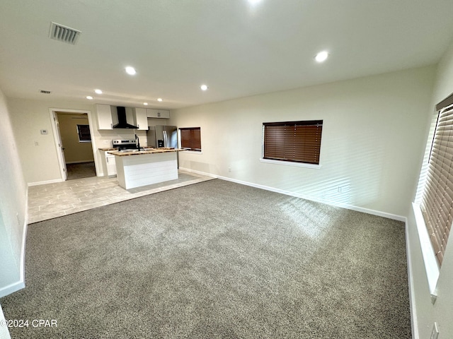 unfurnished living room featuring light colored carpet