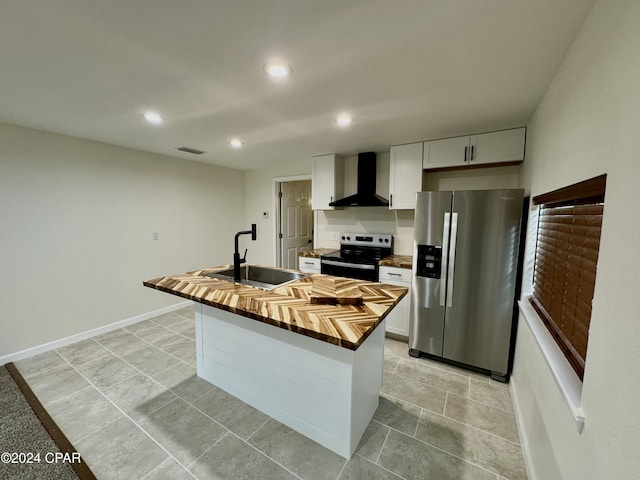 kitchen with appliances with stainless steel finishes, wall chimney exhaust hood, white cabinetry, sink, and a center island with sink