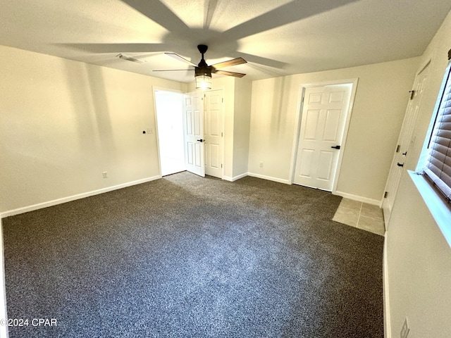 unfurnished bedroom featuring ceiling fan and dark colored carpet